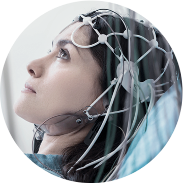 Technik medyczny nakłada żel przewodzący lub dopasowuje czepek EEG na głowie pacjentki.