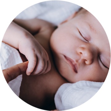 Śpiący noworodek trzymający palec dorosłego – bezpieczne badanie EEG noworodka w Neurodiagnostyce.